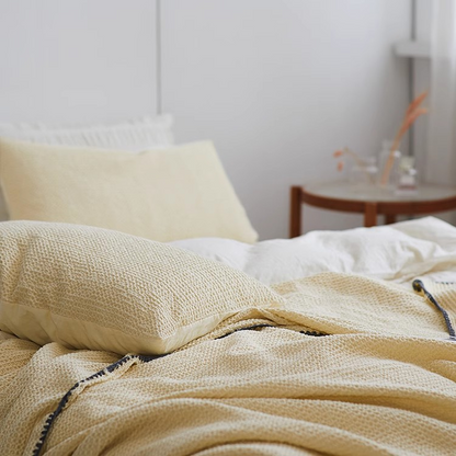 Close-up view of light yellow 3D honeycomb waffle cotton throw blanket highlighting breathable textured cotton fabric.