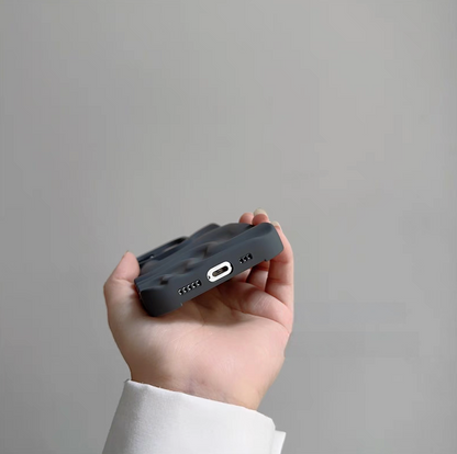 Gray matte silicone phone case showing bottom cutouts for charging port and speakers with 3D wave texture