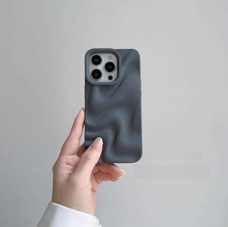 Gray 3D wave matte silicone phone case held in hand showing smooth textured surface and raised camera protection