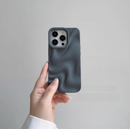 Gray 3D wave matte silicone phone case held in hand showing smooth textured surface and raised camera protection