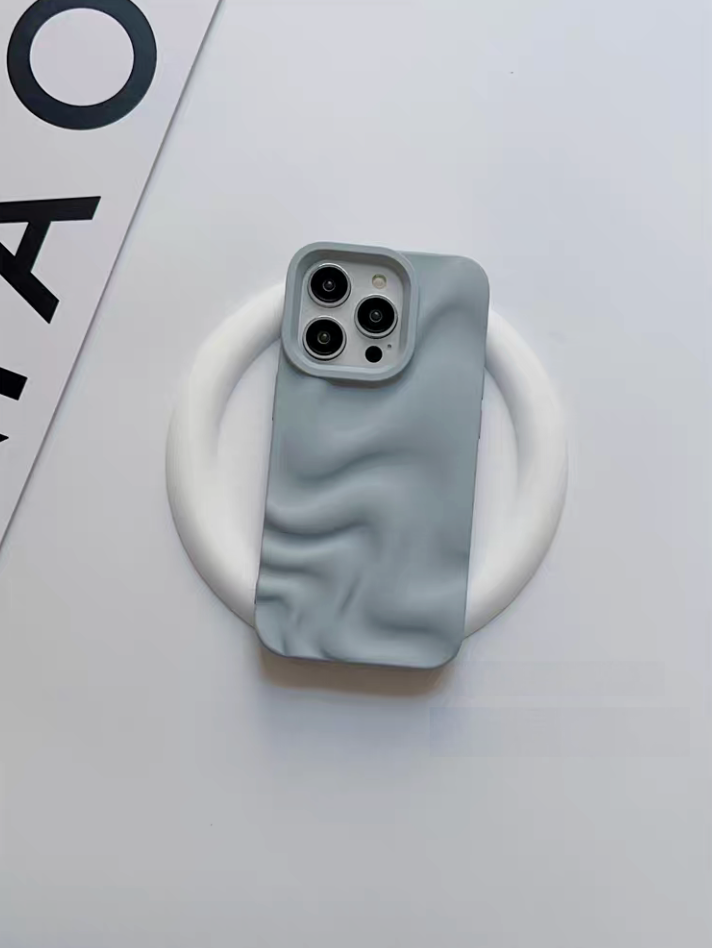 Light blue 3D wave matte silicone phone case placed on a white stand showing soft textured design and camera protection