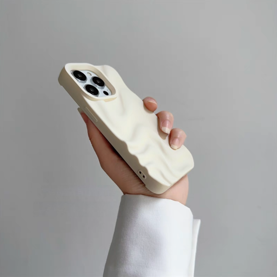 White 3D wave matte silicone phone case held at an angle highlighting slim design and textured surface