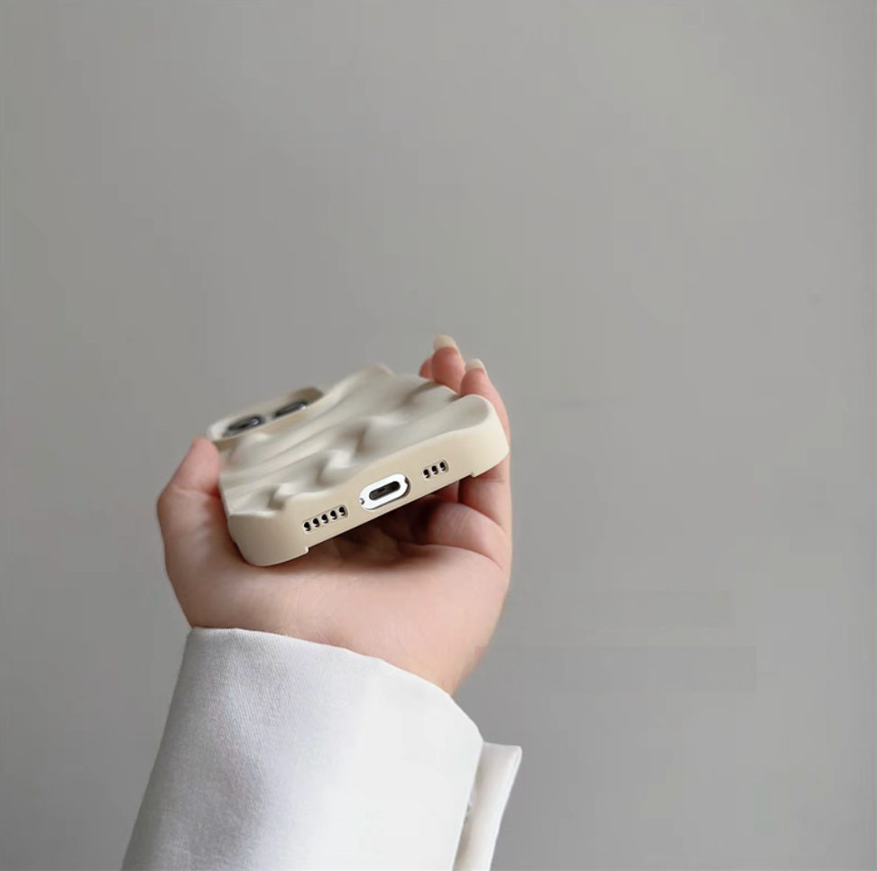 White matte silicone phone case showing bottom cutouts for charging port and speakers with 3D wave design