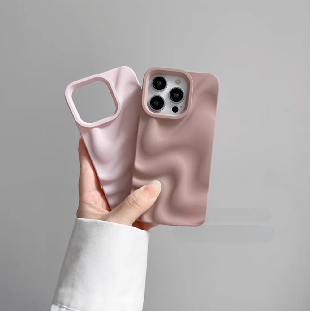 Light pink and dark pink 3D wave silicone phone cases held in hand, showing matte finish and raised camera protection