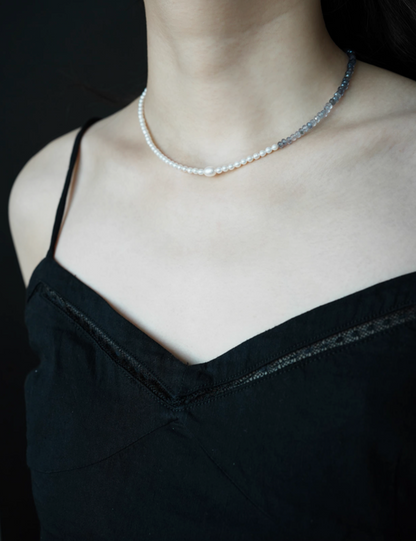 Model wearing harmony pearl and gem necklace featuring half pearl and half blue gray natural stone design with minimalist elegant look