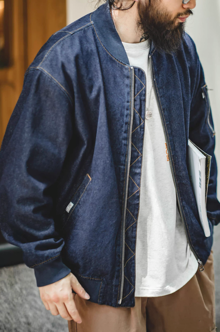 Model layering denim MA-1 bomber over white tee and brown chinos