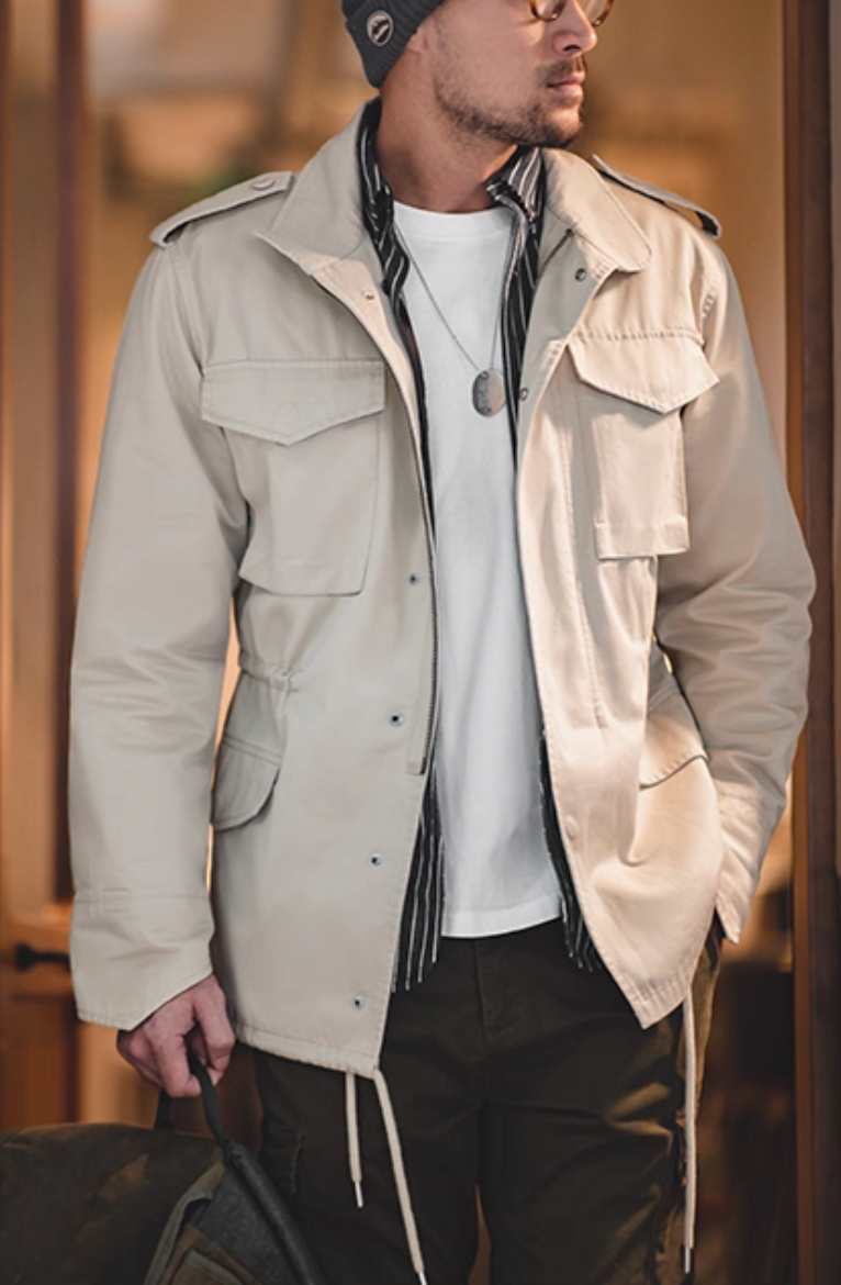 Model in Sand Beige M65 Field Jacket layered over white tee and striped shirt