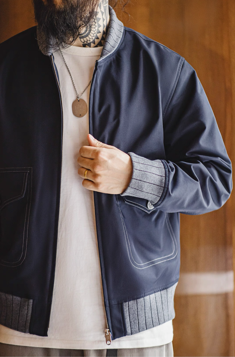 Close view of man wearing navy bomber jacket with ribbed cuffs