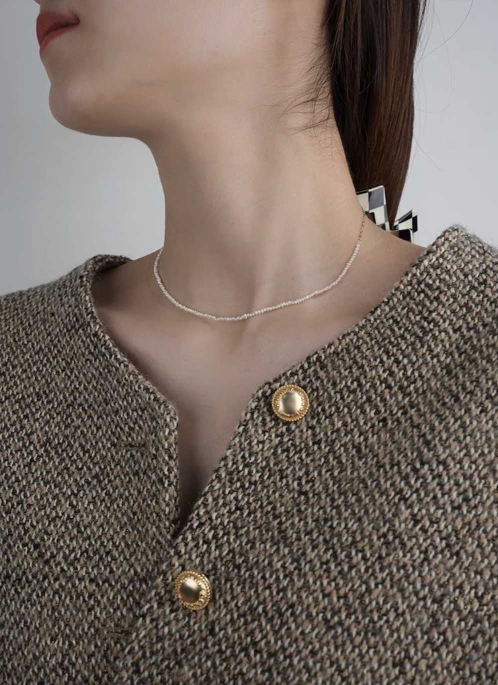 Side view of model wearing rice pearl necklace with 14K gold-filled accents in Style A with layered pearl strands