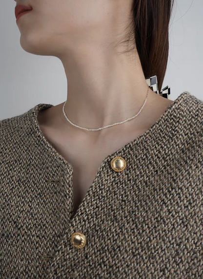 Side view of model wearing rice pearl necklace with 14K gold-filled accents in Style A with layered pearl strands