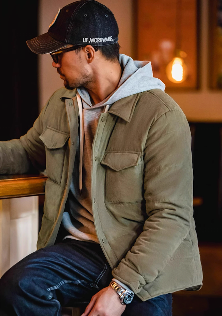 ide view of Olive Green Softshell Puffer Overshirt on model in café setting