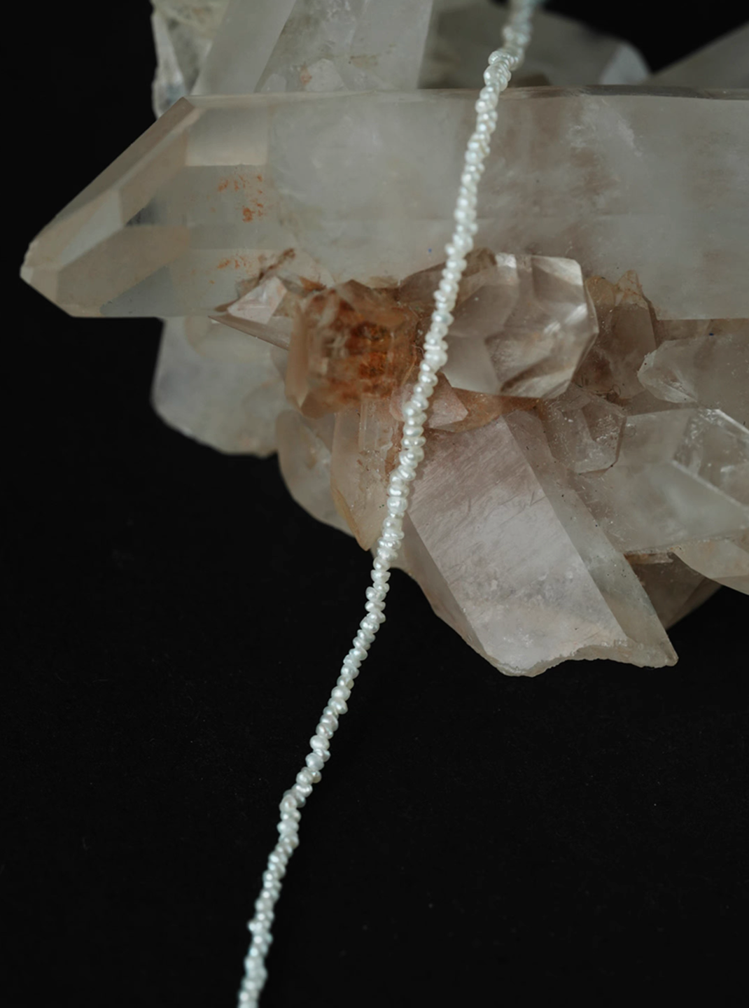 Close-up of wild pearl silver choker on crystal showing ultra-fine freshwater pearls with delicate natural texture and soft luster