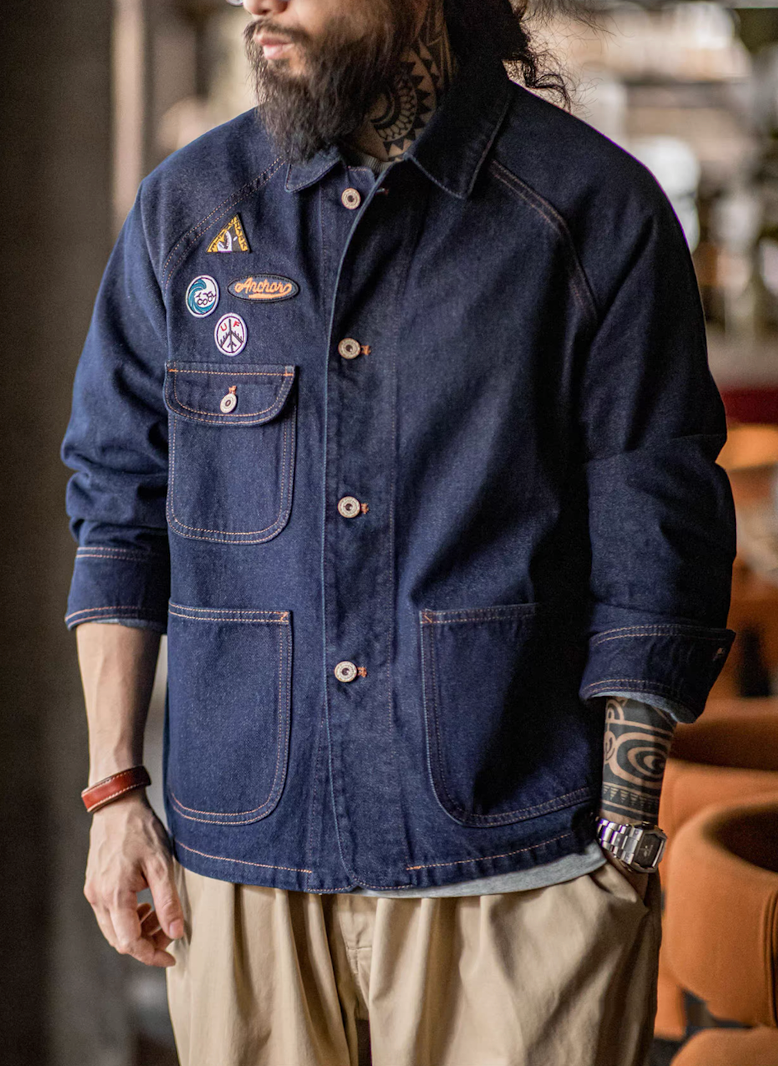 Front view of man wearing denim workwear jacket with patches