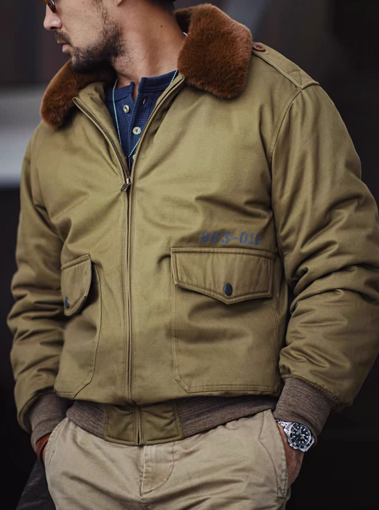Side view of man wearing B-10 jacket, highlighting chest pockets and ribbed cuffs.