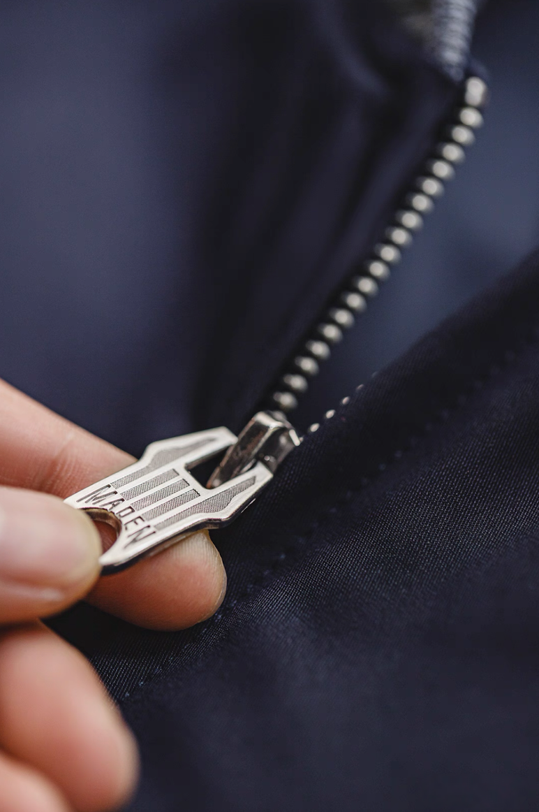 Close-up of silver zipper detail on navy A1 flight jacket
