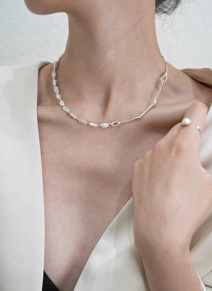 Model wearing Nature’s Grace baroque pearl branch necklace with hand detail highlighting pearls and silver branch chain