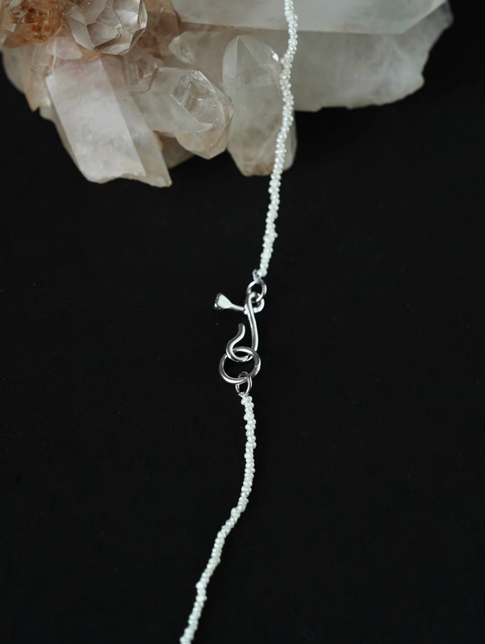 Detail of wild pearl silver choker clasp and chain featuring ultra-fine freshwater pearls and secure minimalist silver closure