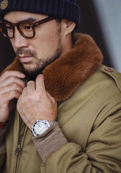Close-up of plush faux-fur collar and shoulder seam of olive B-10 flight jacket.