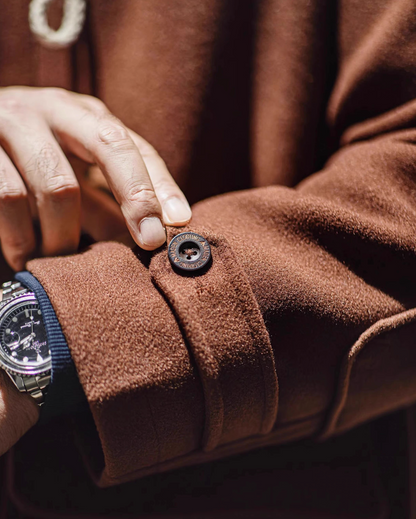 Close-up of cuff button design on brown duffle coat sleeve