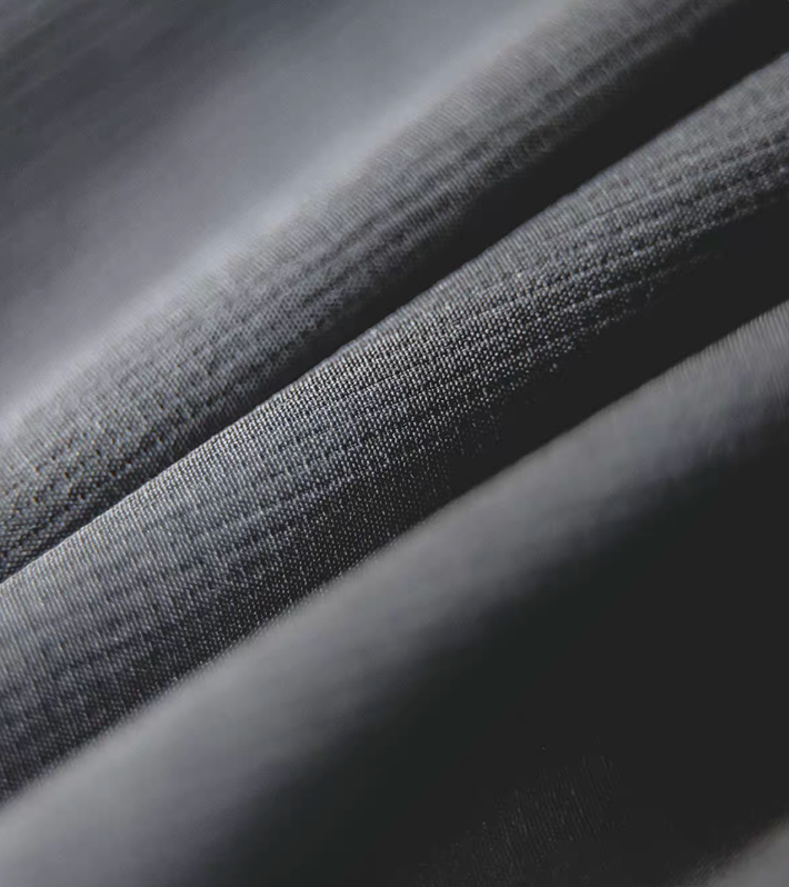 Detailed close-up of dark charcoal overshirt jacket fabric texture showing weave.