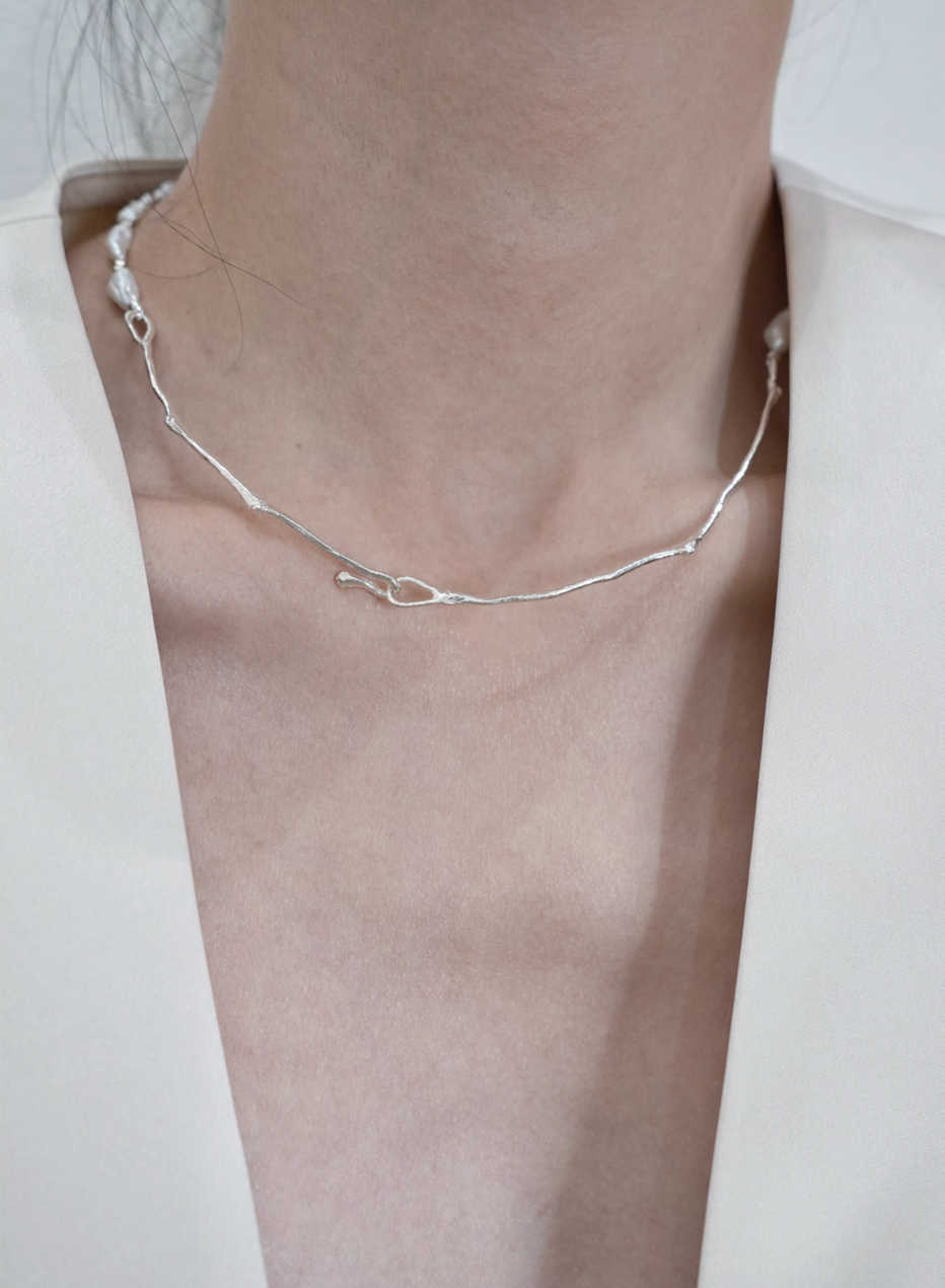Model wearing Nature’s Grace baroque pearl branch necklace back view showing silver branch chain and clasp detail