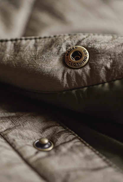 Metal snap button engraved with brand lettering on nylon fabric