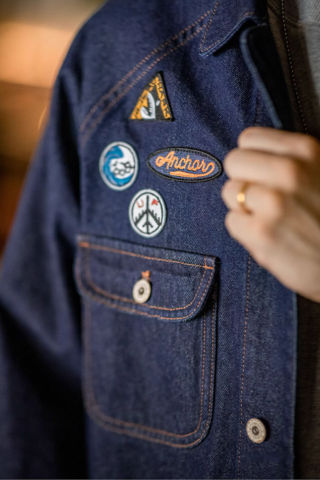 Detailed close-up of embroidered patches on denim jacket