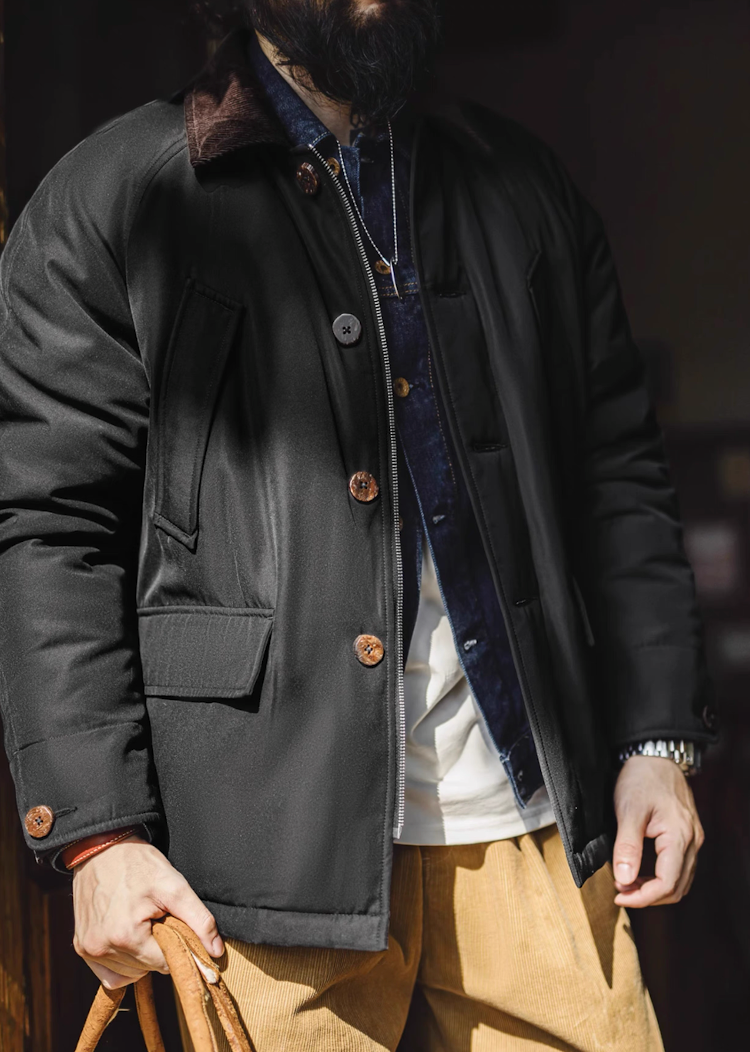 Man wearing black safari workwear jacket styled with denim and corduroy pants