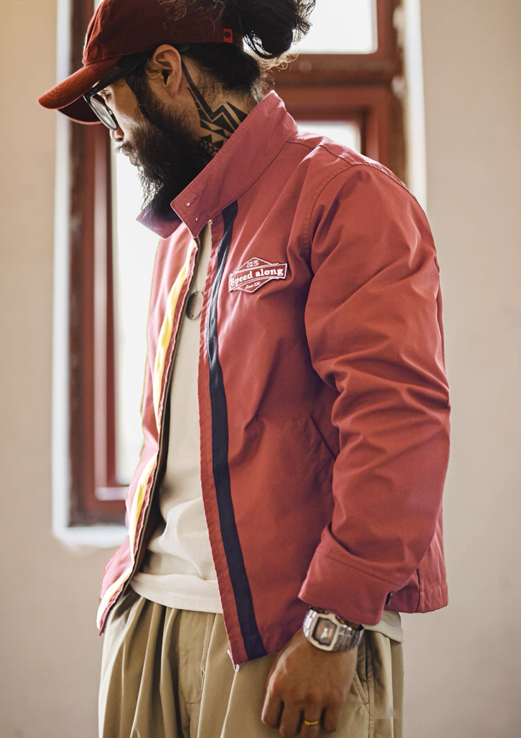 Model side profile wearing brick red 60s racing jacket with contrast stripes