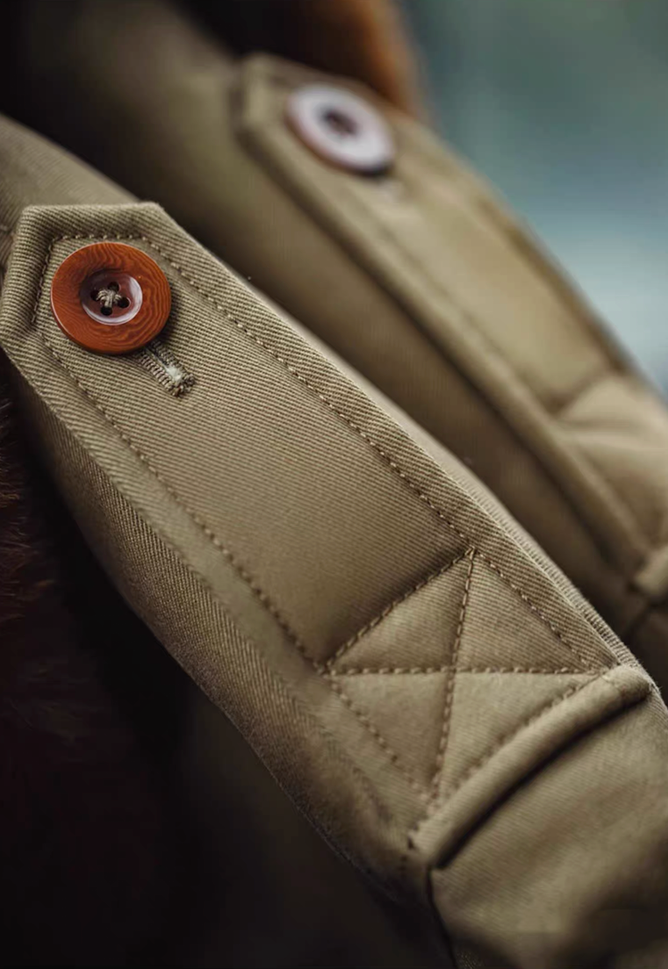 Detailed shot of shoulder epaulet with button and reinforced stitching on B-10 jacket.