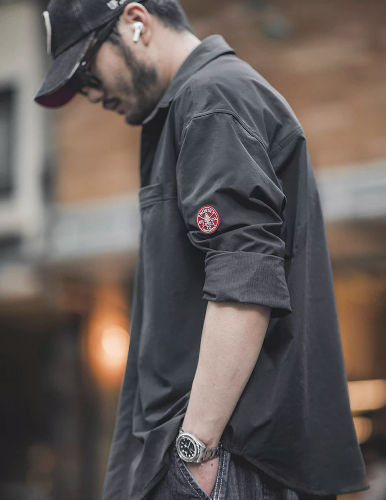 Side view of model wearing men’s dark charcoal overshirt jacket, showing relaxed silhouette.