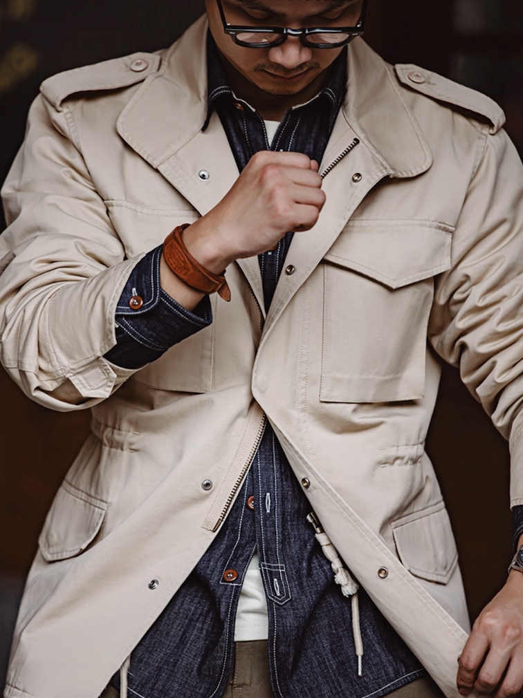 Model wearing M65 Field Jacket over denim shirt showcasing rugged layering style