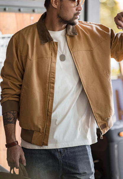 Man in khaki Santafe canvas workwear bomber jacket styled with white t-shirt.