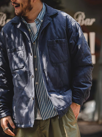 Man wearing navy blue quilted jacket over striped shirt