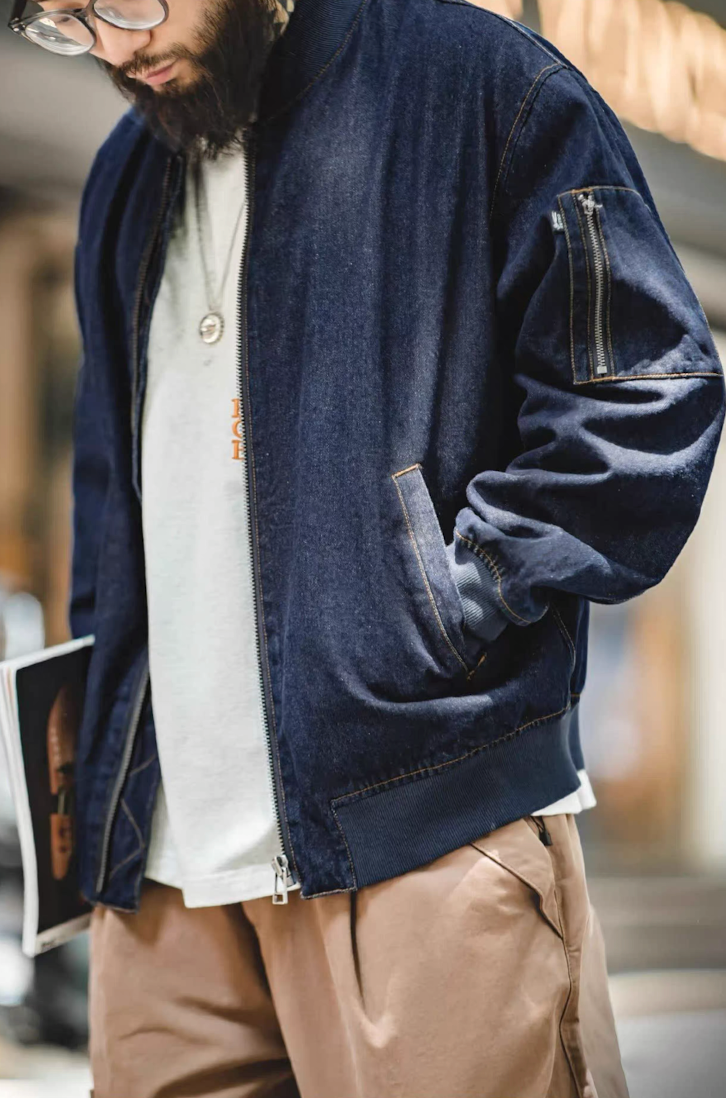 Model walking outdoors wearing denim MA-1 jacket with casual layers