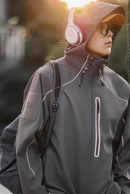 Model wearing grey LIGHTSABER waterproof jacket in natural outdoor light