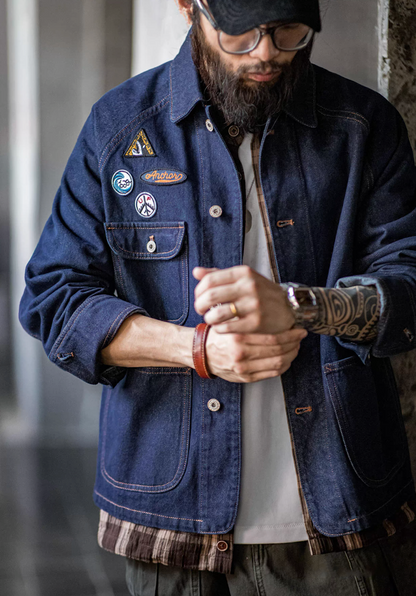 Man adjusting cuff of denim chore jacket showing patch details