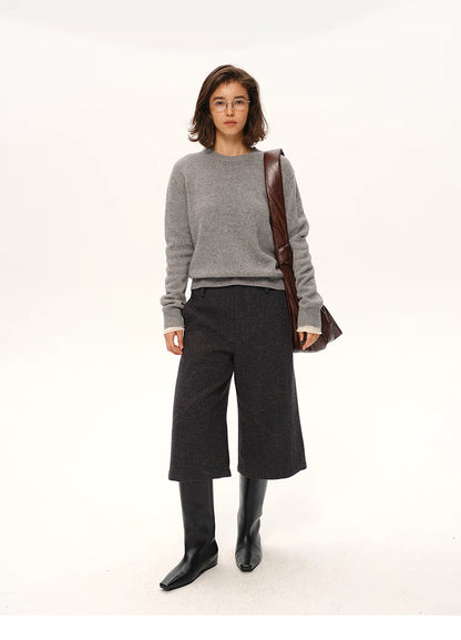 Full-body look of gray cashmere-blend sweater styled with dark culottes and knee boots.