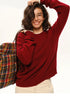 Woman wearing wine red cashmere-blend crewneck sweater smiling with plaid backpack.