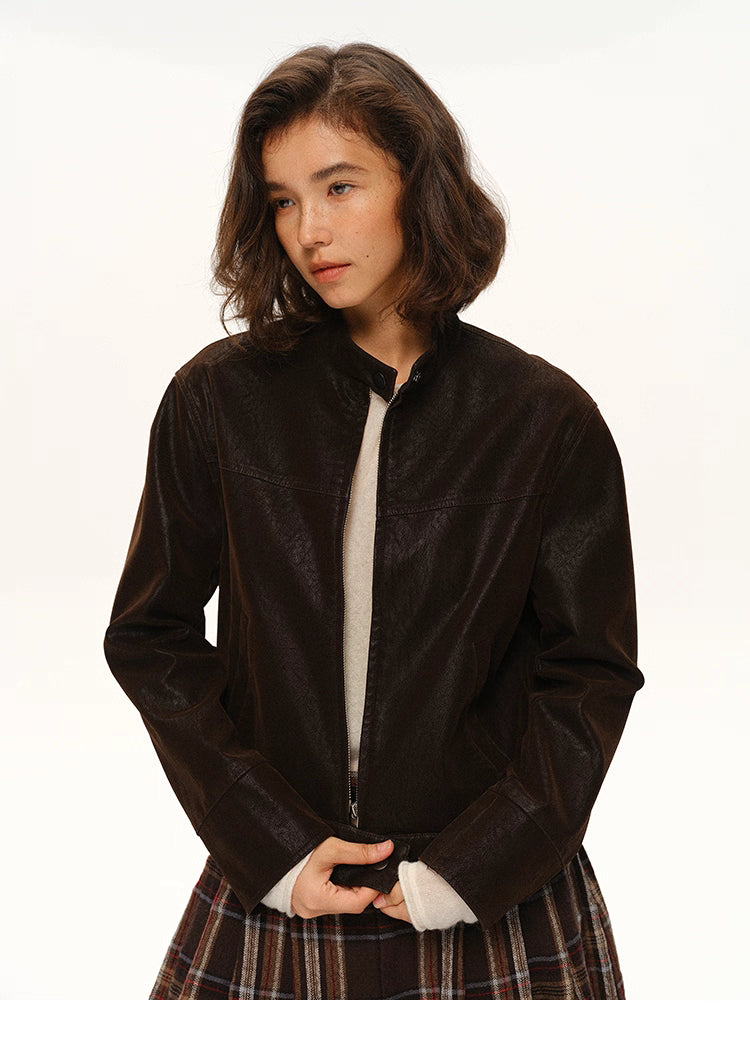 Woman wearing cocoa suede-look moto jacket, front half-body view with zipper partially open.