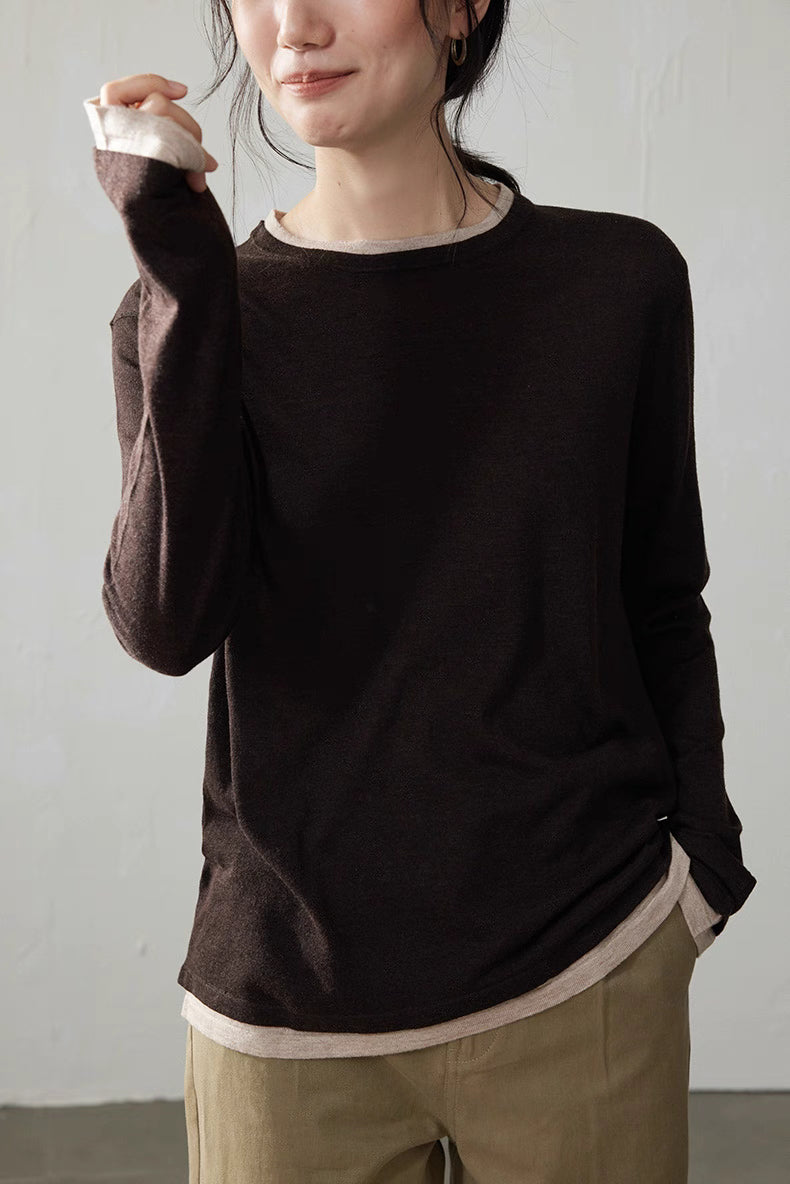 Model smiling in dark brown cashmere blend top showing beige contrast neckline and cuffs