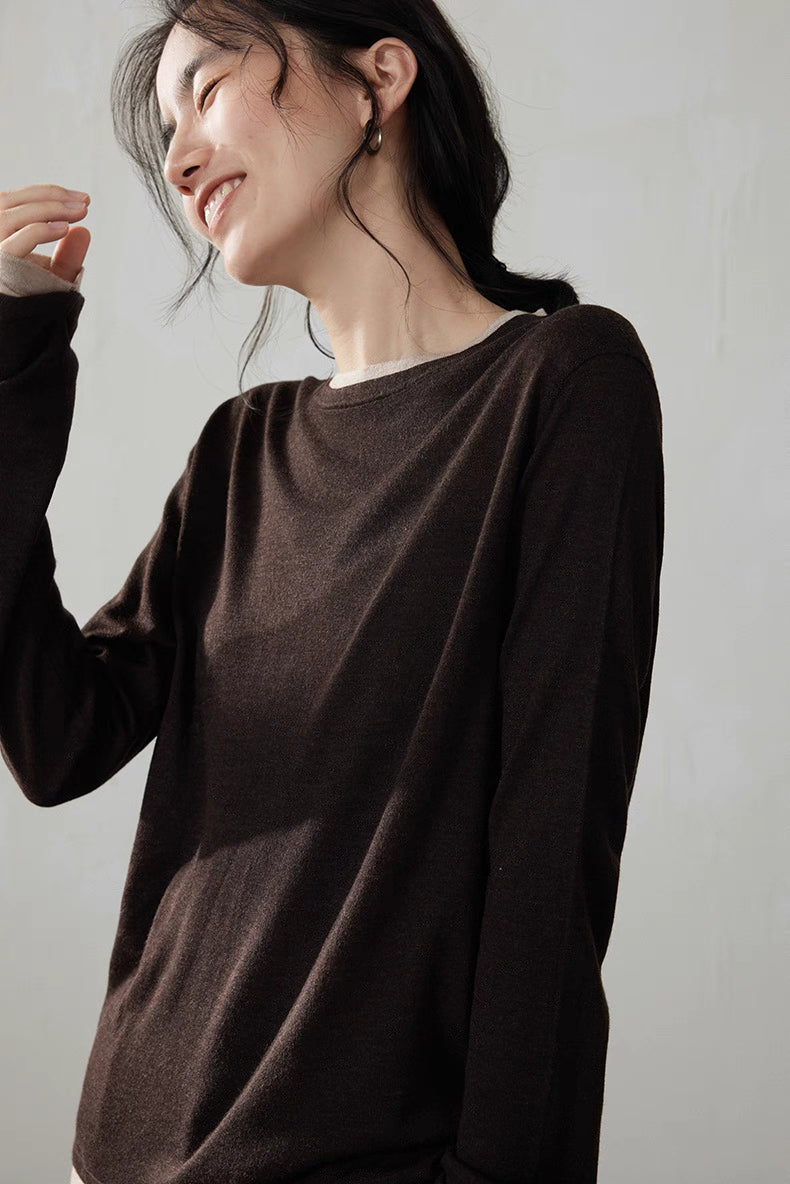 Side view of model smiling wearing dark brown wool cashmere top in warm lighting