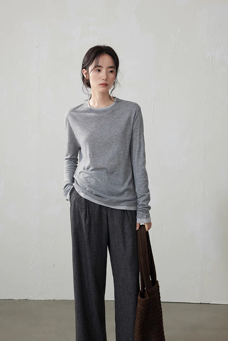 Side view of model in light gray wool cashmere top and dark gray pants standing relaxed