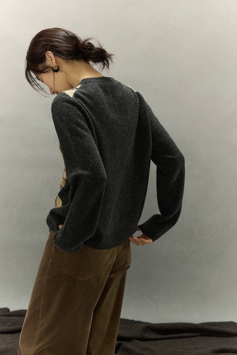 Back view of model showing dark gray wool cardigan with ribbed hem and soft knit texture