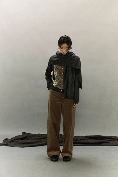 Model with scarf draped over cardigan in minimalist studio setting showcasing cozy texture
