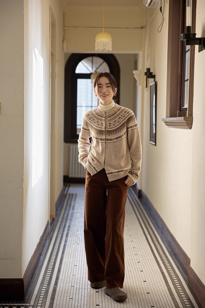Model walking down vintage hallway wearing beige-brown Fair Isle cardigan and brown pants