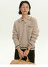 Woman wearing a light camel ribbed wool polo sweater, front view with contrast trim.