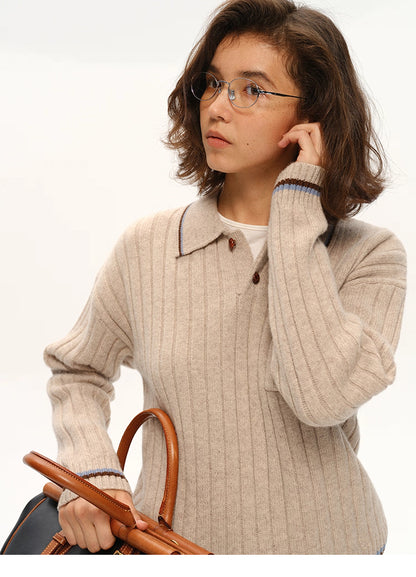 Close-up of collar, buttons, and contrast-trimmed pocket on ribbed wool polo sweater.