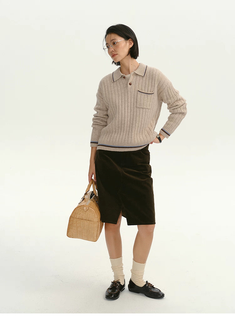 Full-body shot of woman pairing the ribbed wool sweater with a dark skirt.
