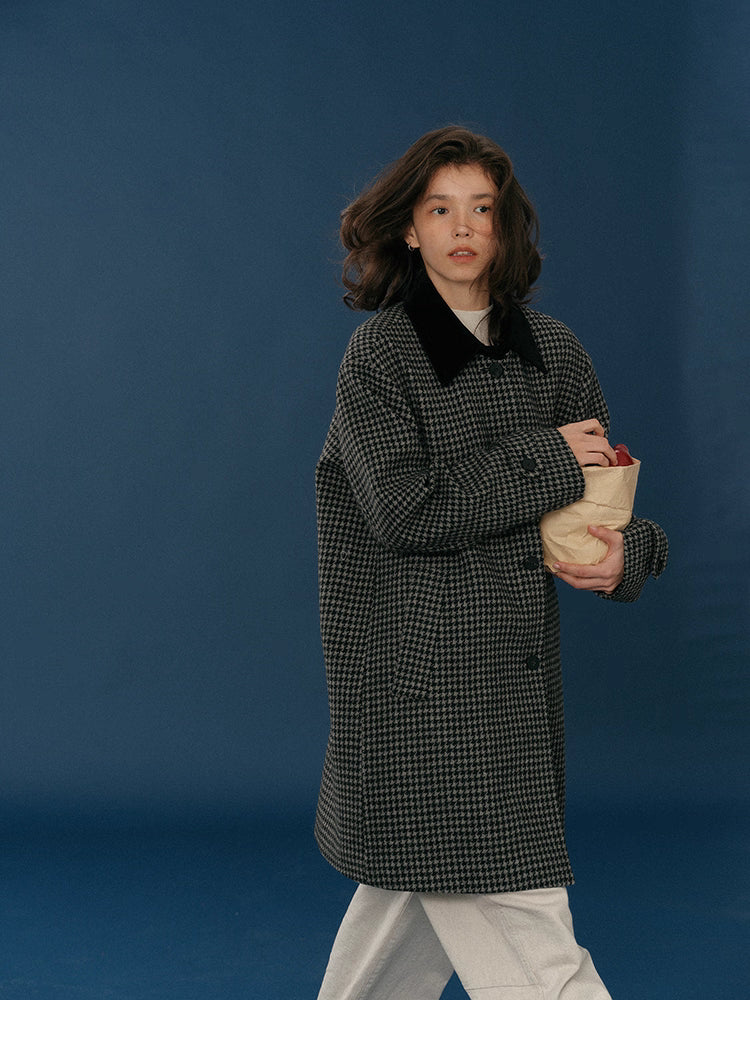 Side walking view showing the coat’s midnight houndstooth pattern and relaxed silhouette.